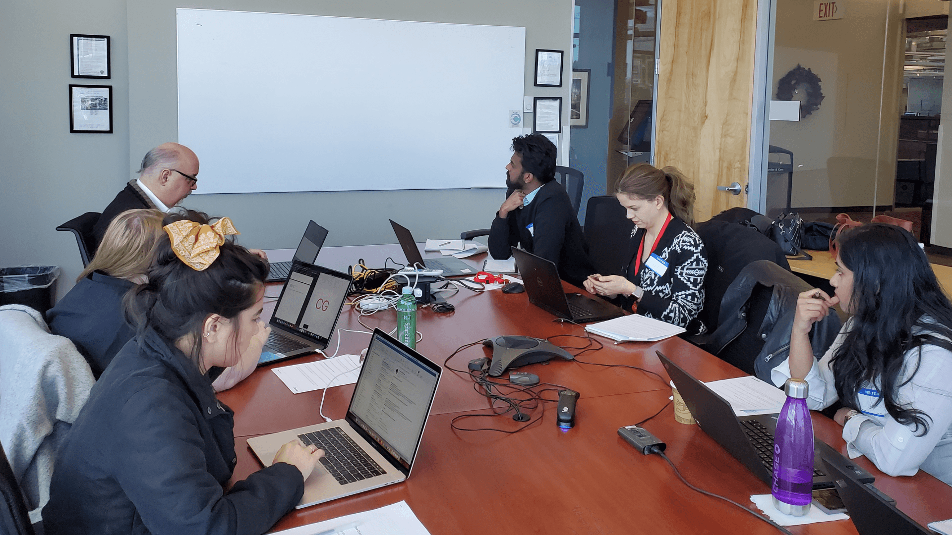Stakeholder interview session around a conference table with laptops